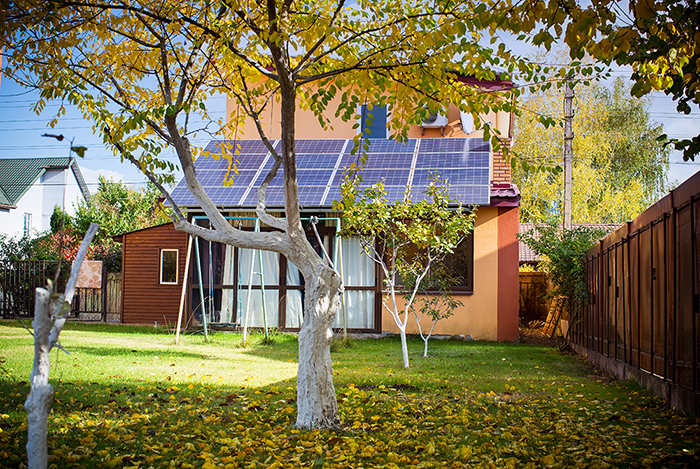 Solar panels installed on the roof of the house. Warm autumn.