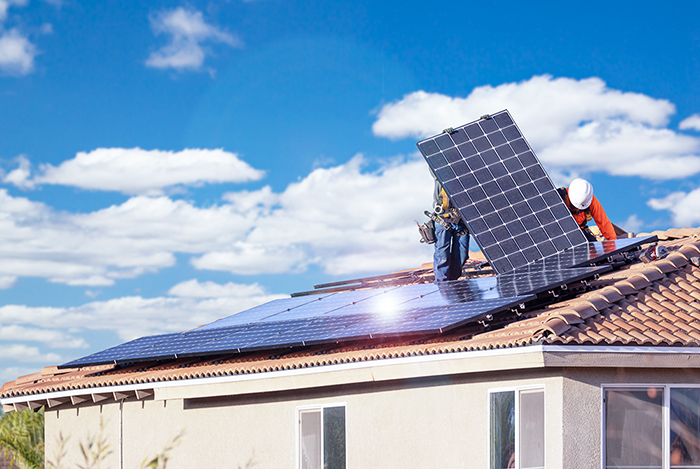 Workers Installing Solar Panels on House Roof.